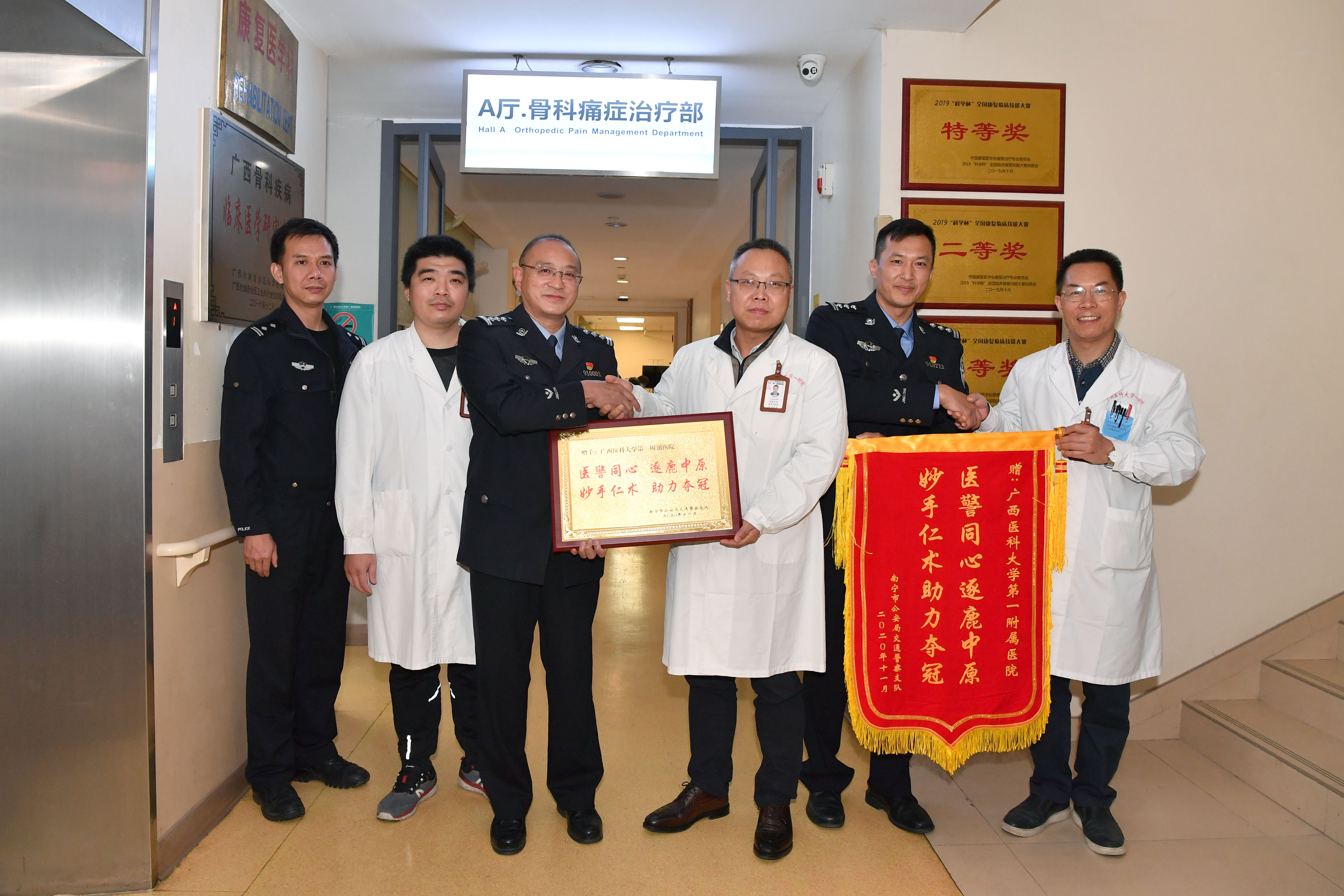 医务部部长尚丽明（中）与许建文教授（右）、治疗师苏毅（左二）接受荣誉牌匾与锦旗